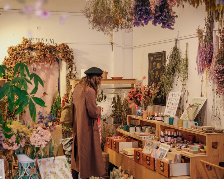 Inside the shop Moonko, on Division Street, a woman is browsing and looking at the displays.