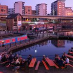 People enjoying a drink, in the evening, around the canal basin at Victoria Quays.