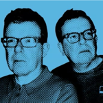 Stylised two-colour graphic portrait of two people wearing glasses, shown from the shoulders up against a light blue background. The image uses a halftone printing effect with black and blue tones, creating a retro pop-art appearance. One person faces slightly left in the foreground while the other stands behind, looking to the side. The design has a bold, poster-like aesthetic with high contrast and simplified details.