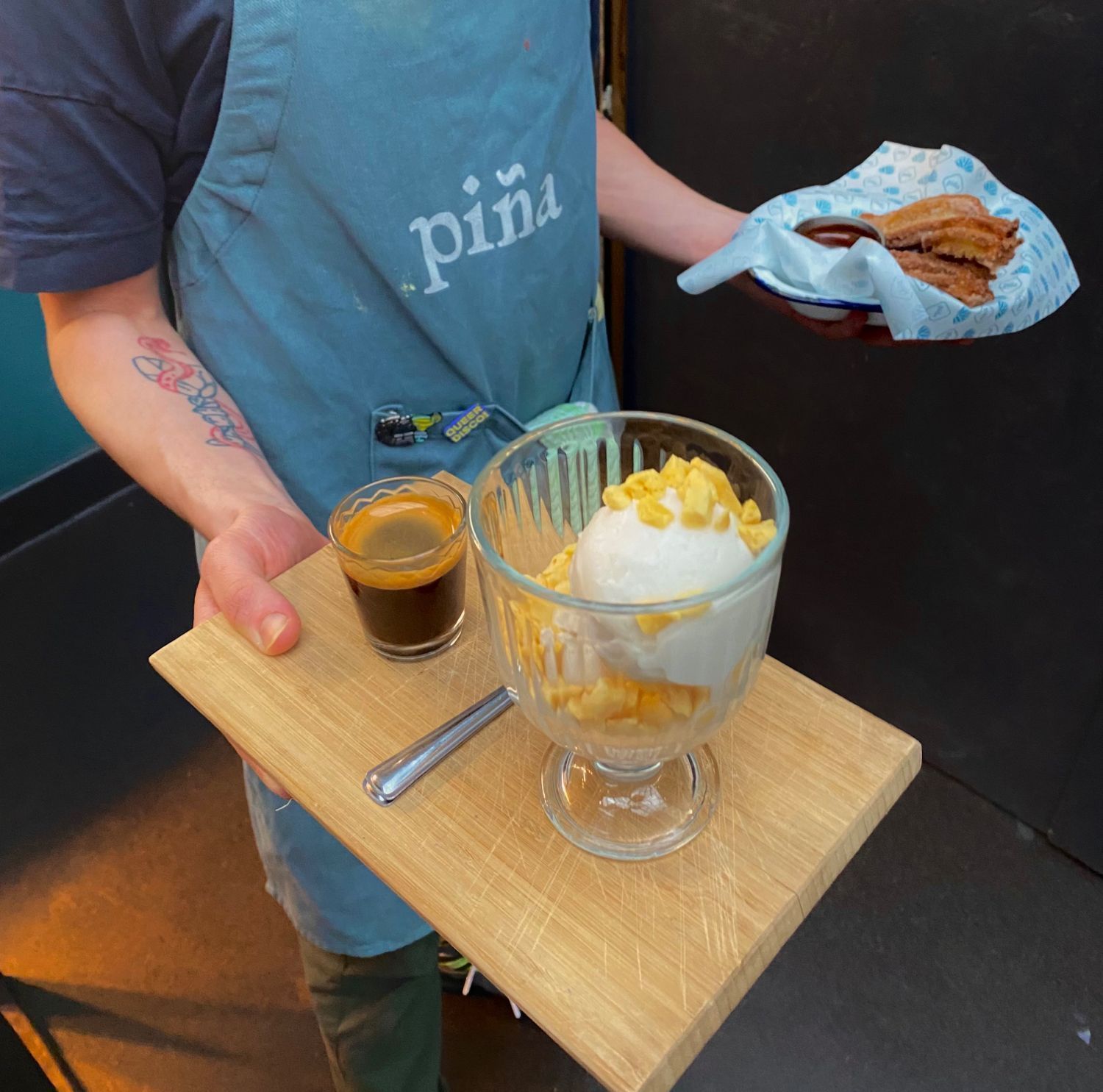 A member of Piña staff carrying food and drinks to a table.