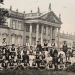 An old black and white image of a group of men posing with Wentworth Woodhouse in the background.