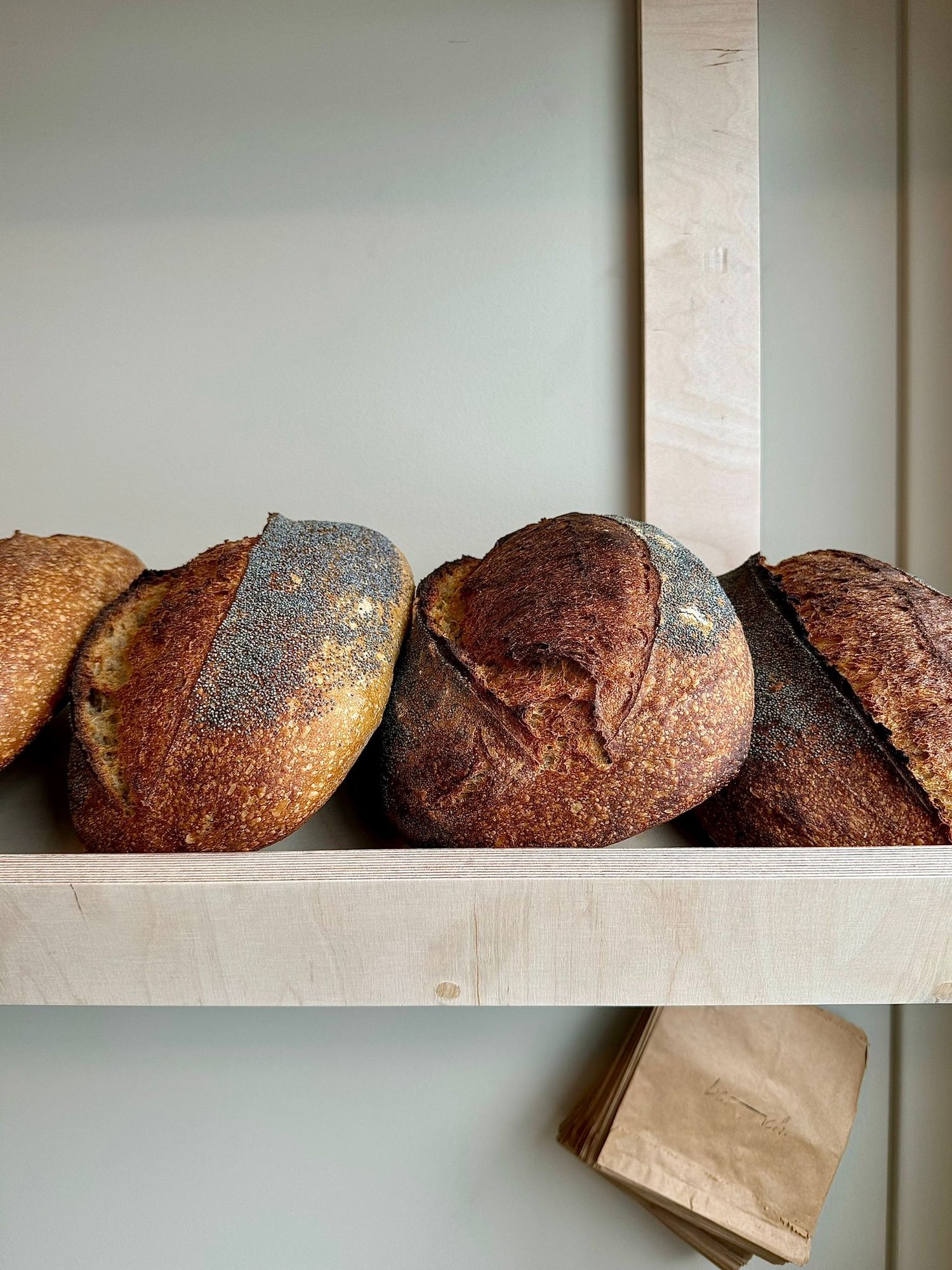 A shelf full of freshly baked bread at Bench La Cave .