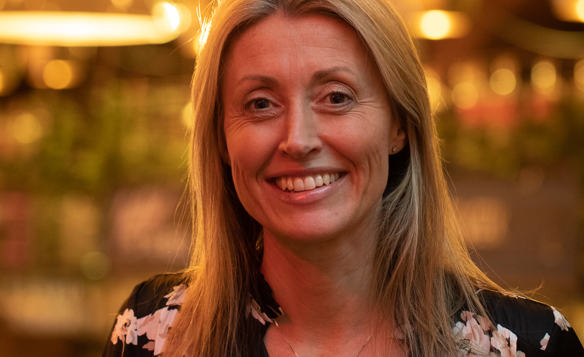 A picture of a female smiling with a blurred background