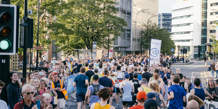 Group of people taking part in Sheffield Half Marathon, running along Arundel Gate.