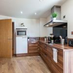 Compact kitchenette with essential appliances and storage cabinets.