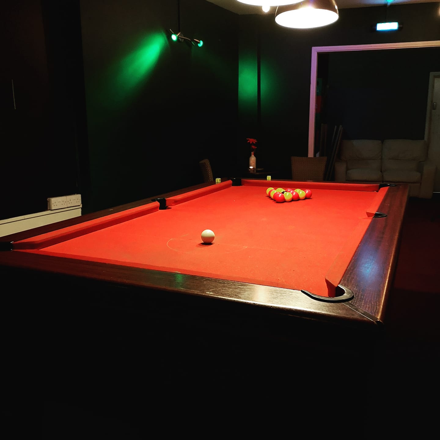 A pool table with a red baize.