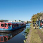 A canal boat motoring along a canal.