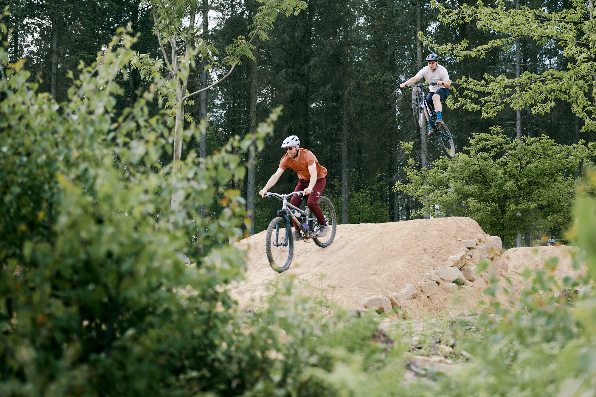Mountain bike riders on a jump at Wharnecliffe and Greno Woods.