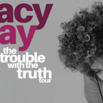 Promotional graphic for Macy Gray’s “The Trouble With The Truth Tour”. Large pink text reading “macy gray” appears on a light grey background, with the tour title in white beneath. On the right, a black-and-white portrait shows Macy Gray leaning on one hand with curly hair, filling the right side of the image. The design is simple and monochrome, with the artist’s name highlighted in bold colour.