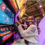 A child having fun playing an arcade style video game.