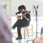 Rory Green sat on a stool, playing guitar.