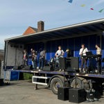 A band playing live on a temporary outdoor stage.