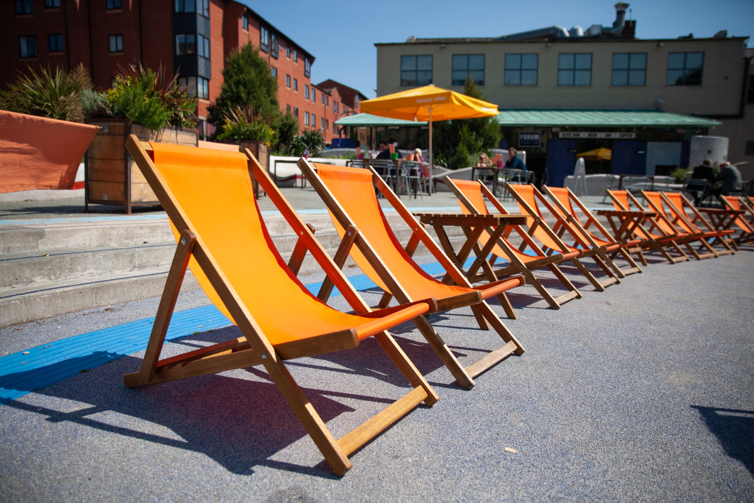 A row of orange deckchairs in the outside seating area at the Forum Kitchen + Bar.