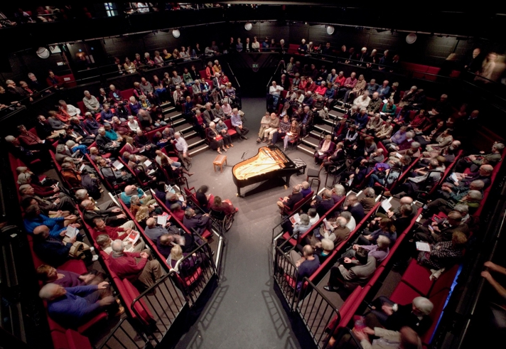 A packed house at the Crucible Theatre waits in anticipation for a classical concert to start. In the centre of the stage stands a grand piano.