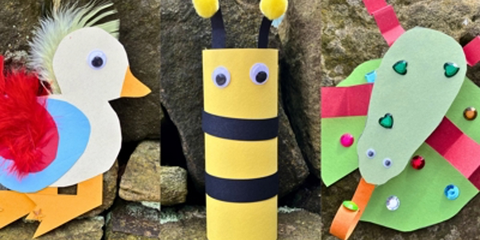 A photo collage showing three colourful children’s craft animals made from paper and recycled materials, displayed outdoors against stone rocks. On the left is a white bird with a yellow beak, red feathered wing, blue circle body detail, and orange legs. In the centre is a yellow and black striped bee made from a cardboard tube, with two googly eyes and two yellow pom‑pom antennae. On the right is a green bug made from layered paper shapes with red stripes, decorated with sequins and a long green paper head