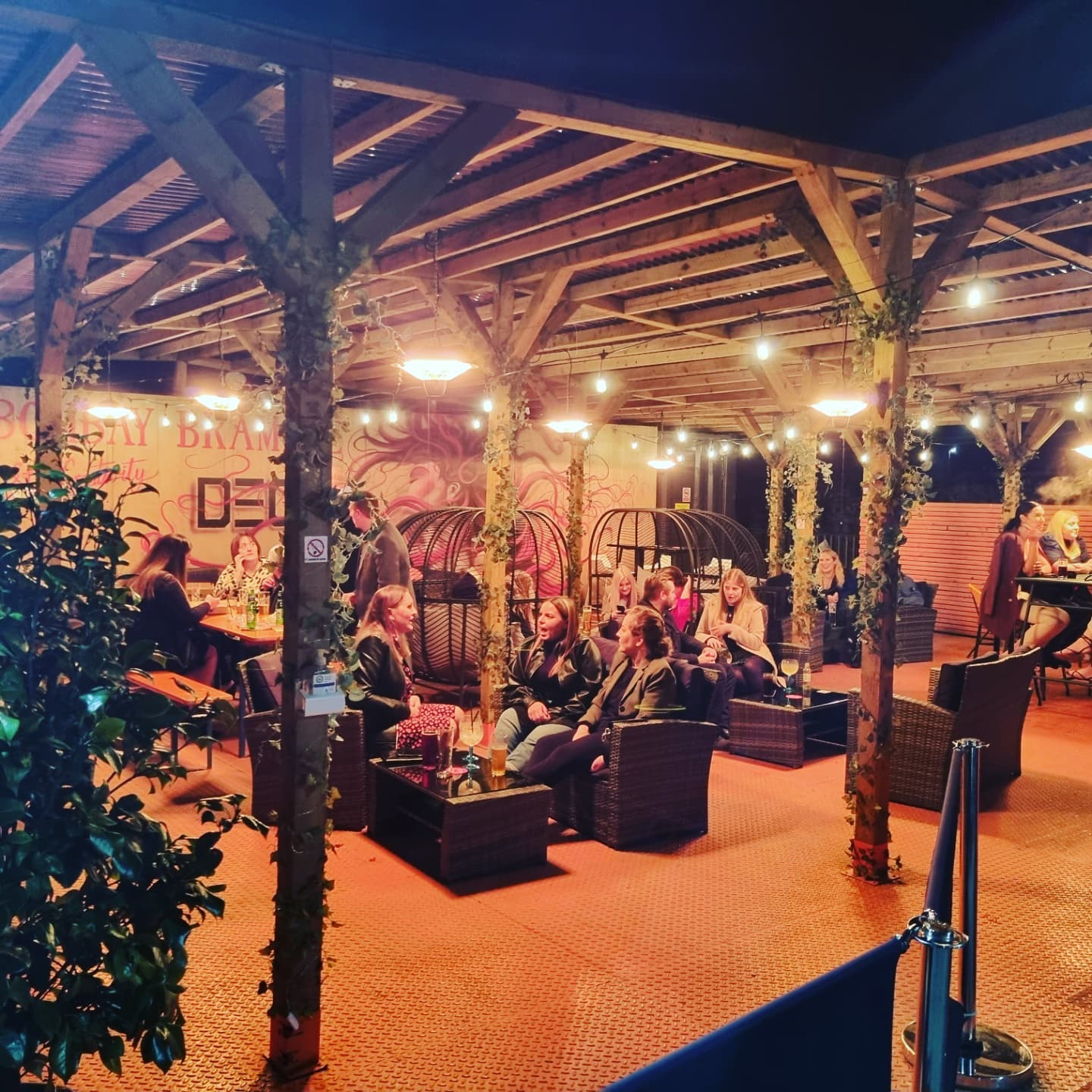 Groups of people sat at tables at Decks in the evening.