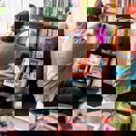 A man stocking a shelf in a book shop.