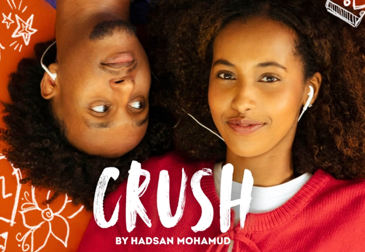 A close up of two people lying on the floor listening to music on a set of shared headphones.