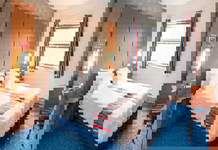 Interior of a twin room at Travelodge Sheffield Meadowhall with two single beds and modern furnishings.