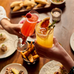 Two people dining at Cosy Club, and enjoying their cocktails.
