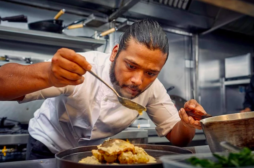 A chef preparing food in the kitchen at Lavang.