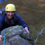 A man smiles as he reaches the top of a climb.