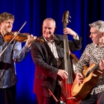 A trio playing guitar, violin and double bass.