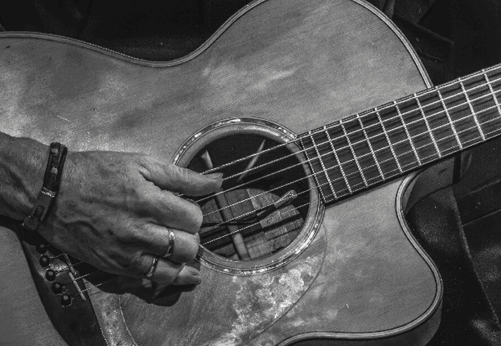 A black and white image of Dylan Fowler playing a classical guitr.