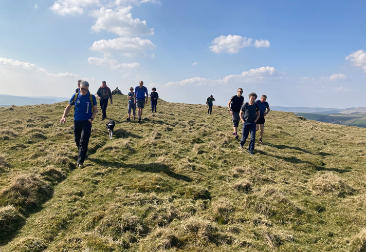 A group of people walking across open moorland. 