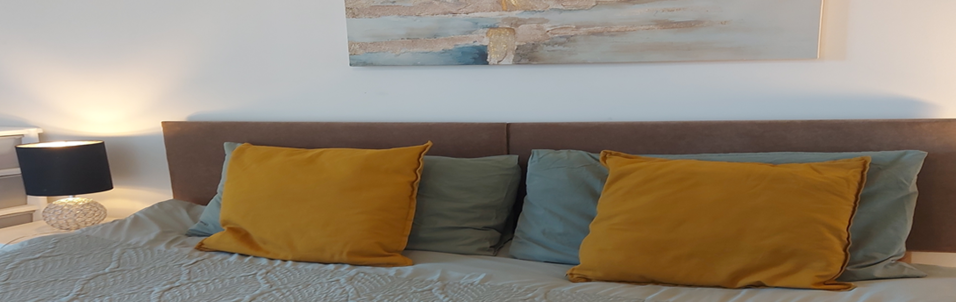 Double bed with soft coloured cushions