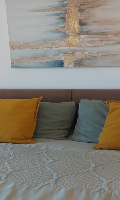 Double bed with soft coloured cushions