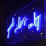 A blue neon sign that reads 'Good vibes only' on the wall at Sheffield Plate.