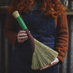 A person in an apron holding a brush.