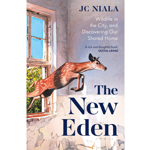 Book cover for The New Eden by JC Niala. An illustrated deer leaps through the broken window of a weathered building into a sunlit room. Green foliage is visible outside beneath a blue sky. The title appears in large dark blue text, alongside the subtitle Wildlife in the City, and Discovering Our Shared Home. A quote from Olivia Laing reads: “A rich and thoughtful book.”