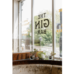 The window with a logo in reverse at The Gin Bar.