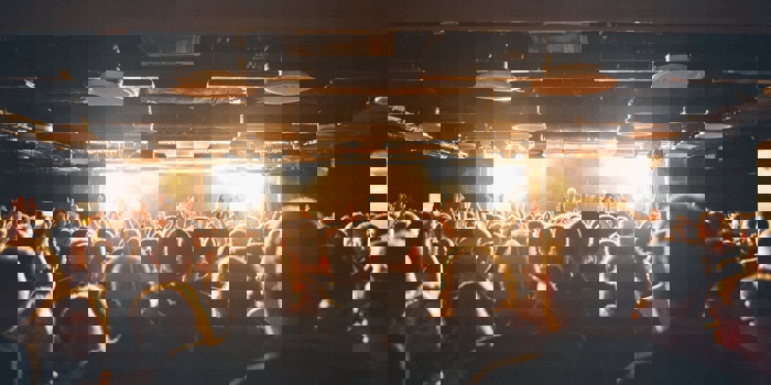 A crowd of people watching a band playing live.