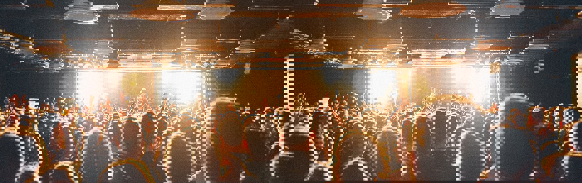 A crowd of people watching a band playing live.