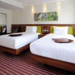 A hotel room with two single beds.