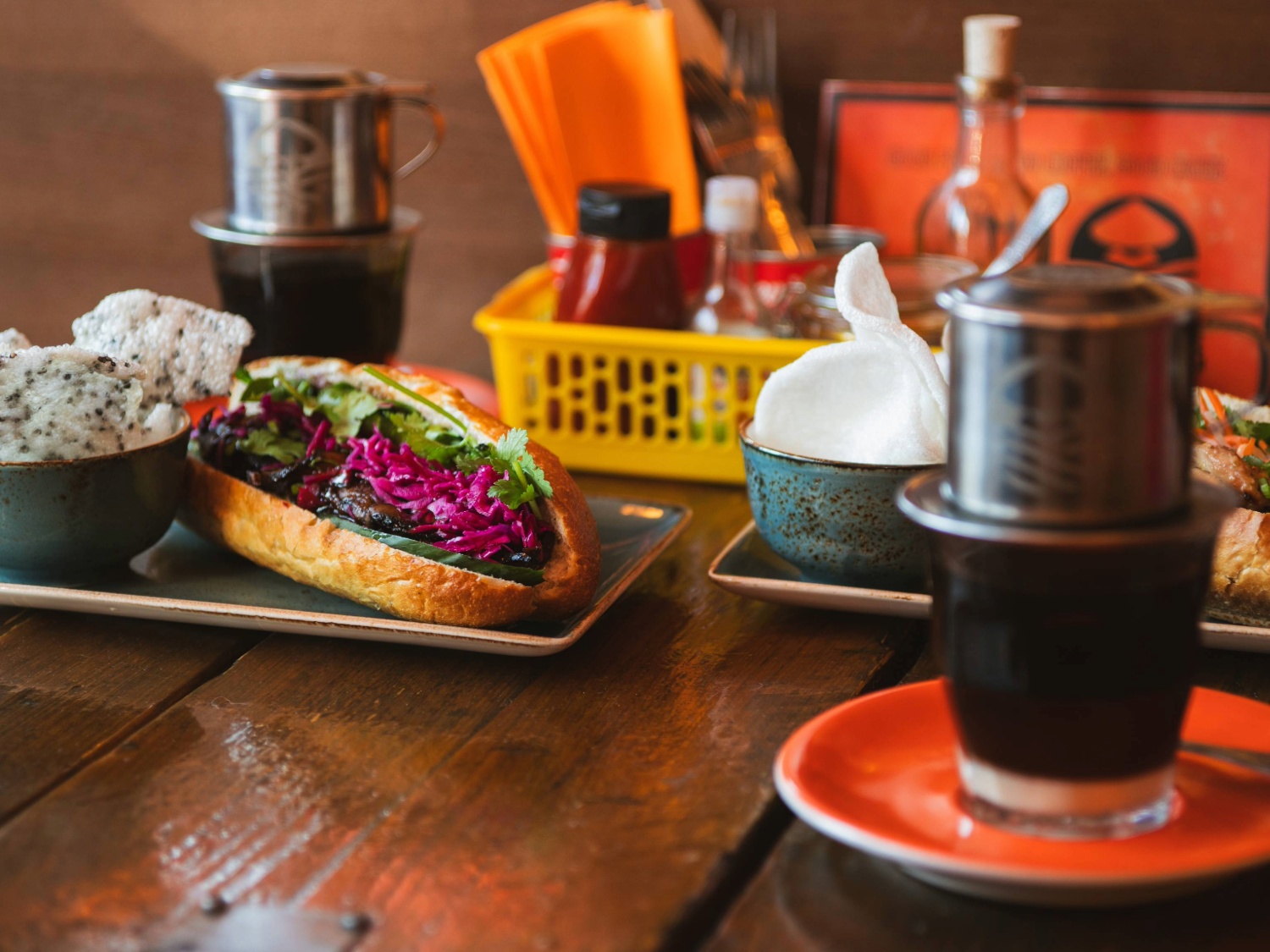 A close-up of several drinks and food dishes on a table.