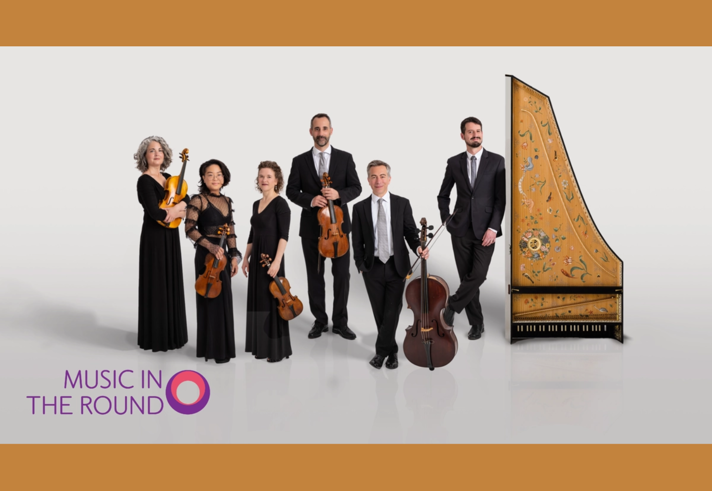 A group of musicians, in smart evening wear, pose with their instruments including a harpsicord standing on its end.