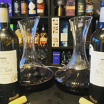 Wine bottles and carafes of wine set out on a table at Gills & Co. 