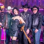 A band posing with their instruments. They have a strong Country influence with lots of Cowboy hats, denim and waistcoats.