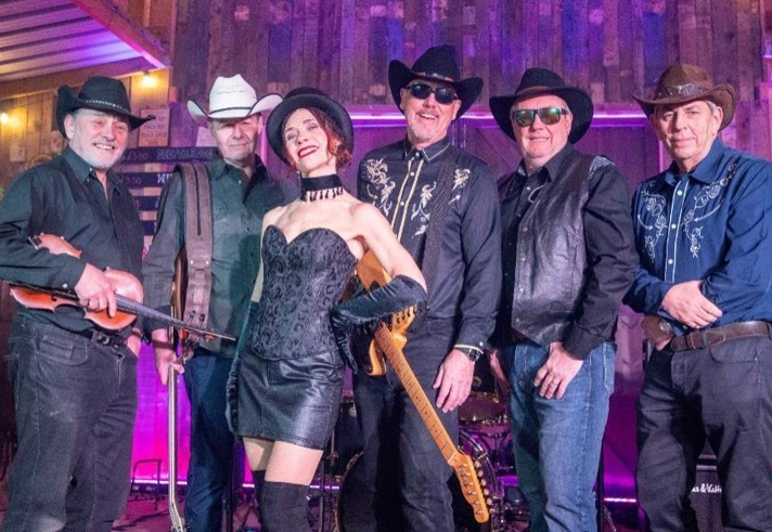 A band posing with their instruments. They have a strong Country influence with lots of Cowboy hats, denim and waistcoats.