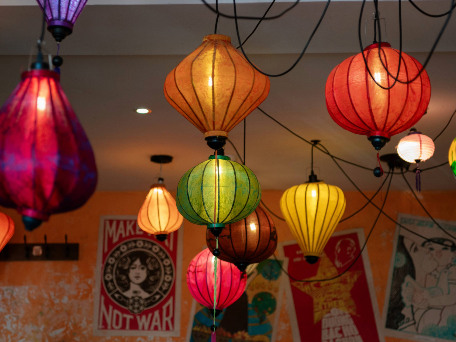 An array of brightly coloured Vietnamese lanterns hang from a ceiling.