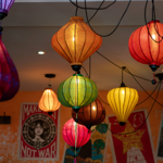 An array of brightly coloured Vietnamese lanterns hang from a ceiling.
