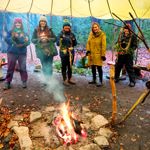 Five women are holding up wreaths they have made at TRIBE Bushcraft Centre.