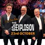 Promotional poster for live music from The 60s Explosion. Three performers in dark suits stand in front of a night sky filled with colourful fireworks. Large central text reads “The 60s Explosion”, with “Live Music From...” above and “23rd October” below in bold orange lettering. The design uses a black background with pink, red, blue and gold fireworks to create a festive concert-themed atmosphere.