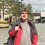 Marcus Newton, the guide for Sheffield City Walking, standing in Tudor Square on a bright, sunny day.