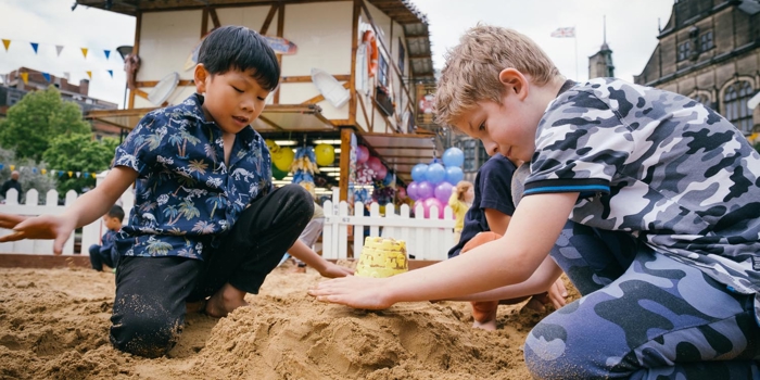 Children are playing in a sandpit that has been set up in the Peace Gardens in Sheffield city centre as part of the Sheffield By The Seaside event.