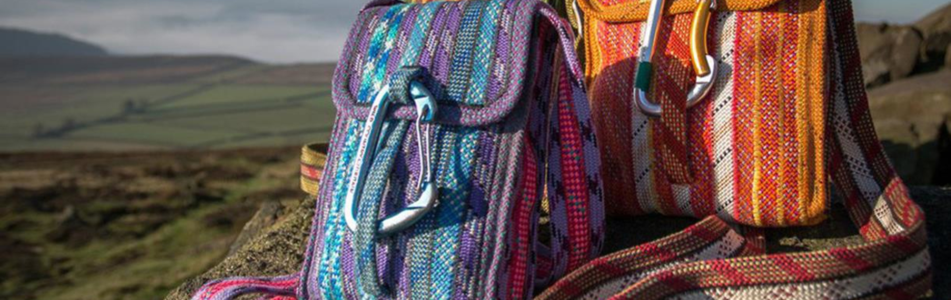Two bags sat on a rock in the countryside.